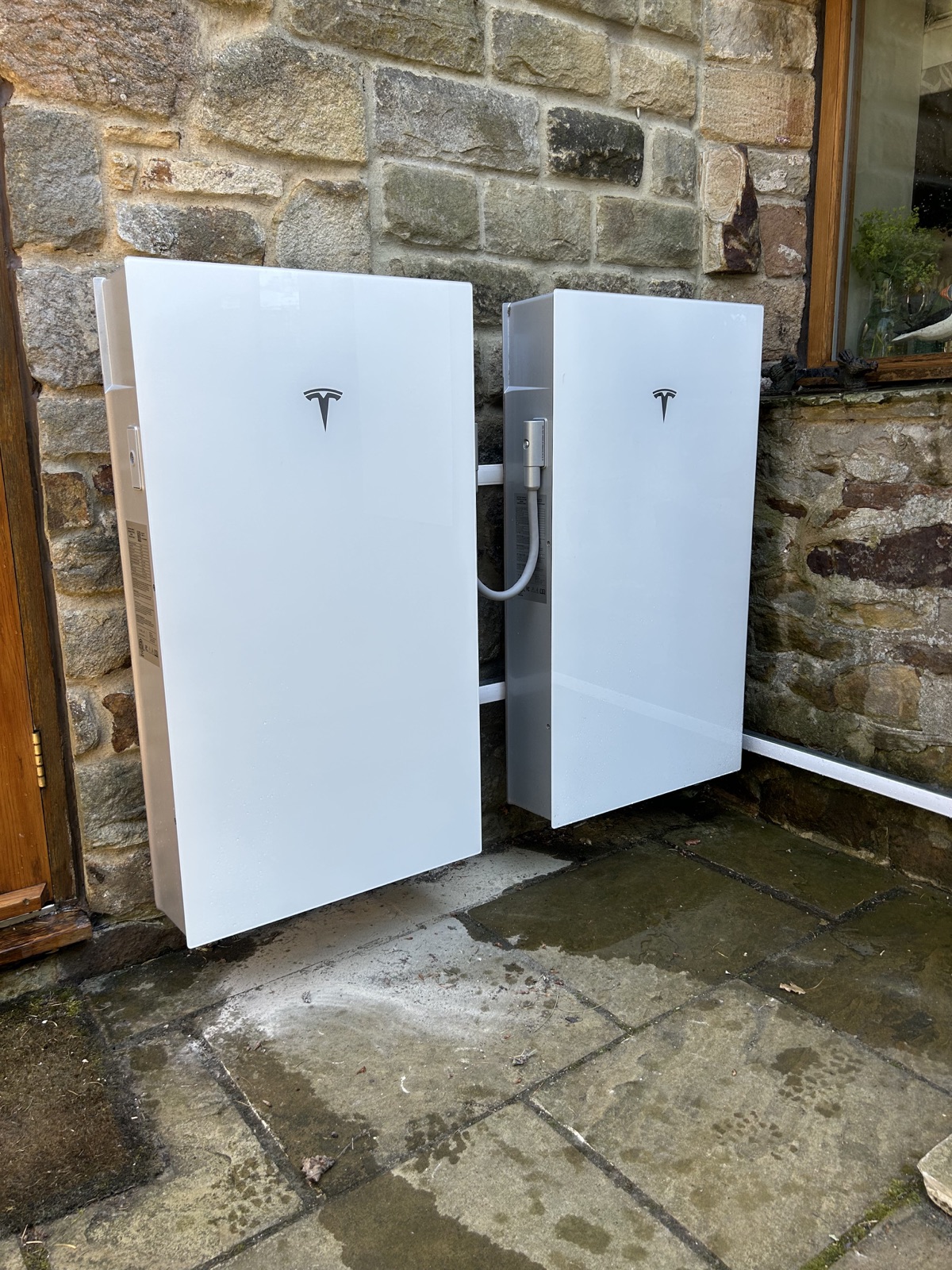 Tesla Powerwall 3 and expansion packs installed on a stone property